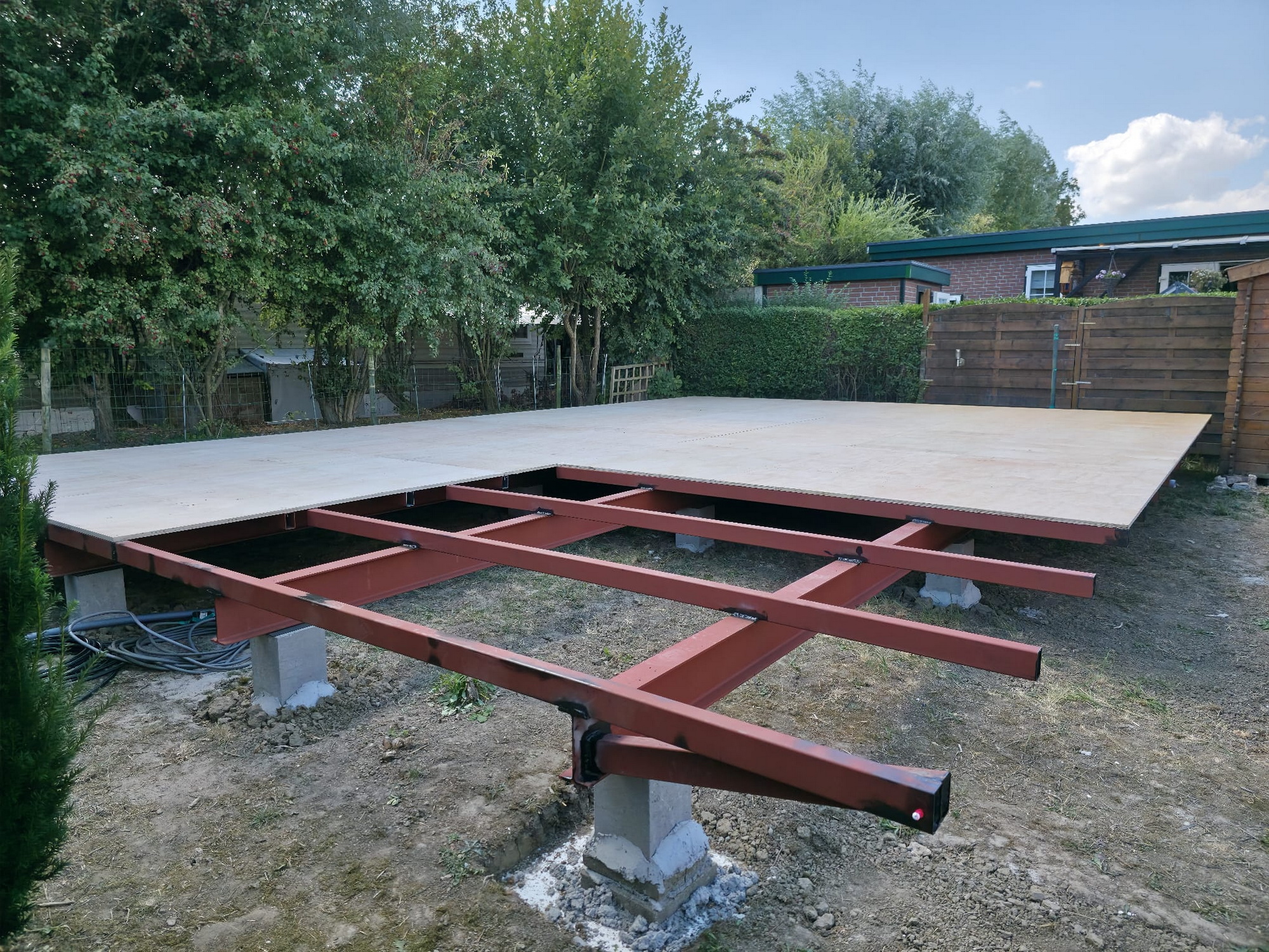 Completed floor deck of boards mounted on the steel frame and concrete piers