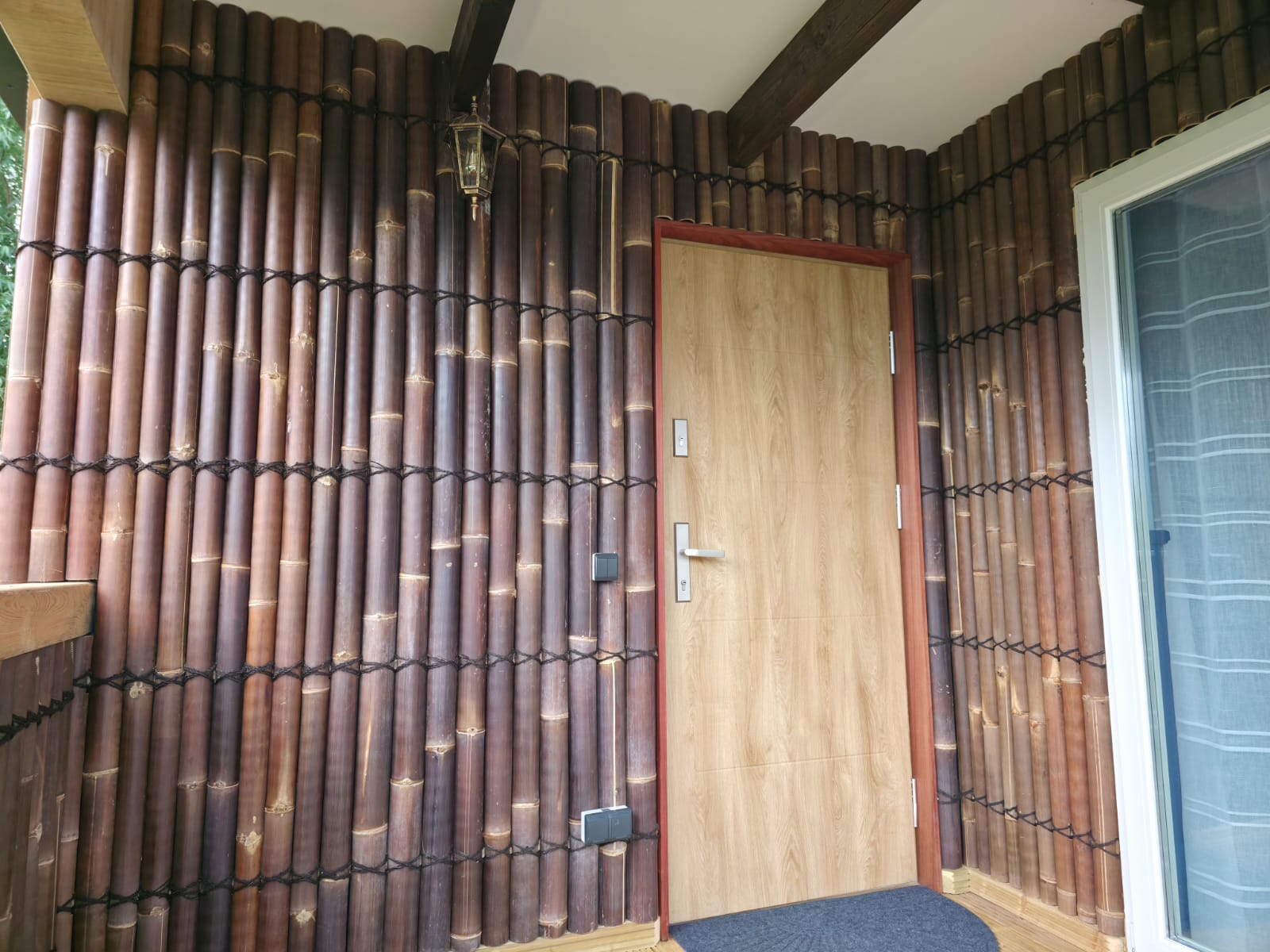 Finished entrance with bamboo wall covering and timber door