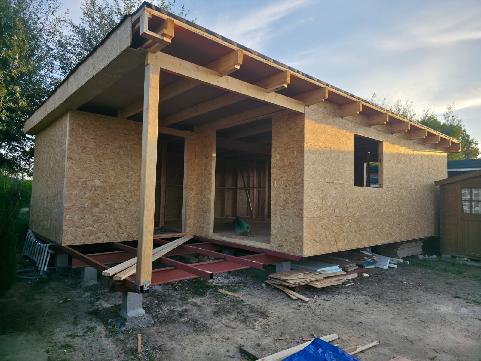 Enclosed timber shell with covered terrace and roof structure