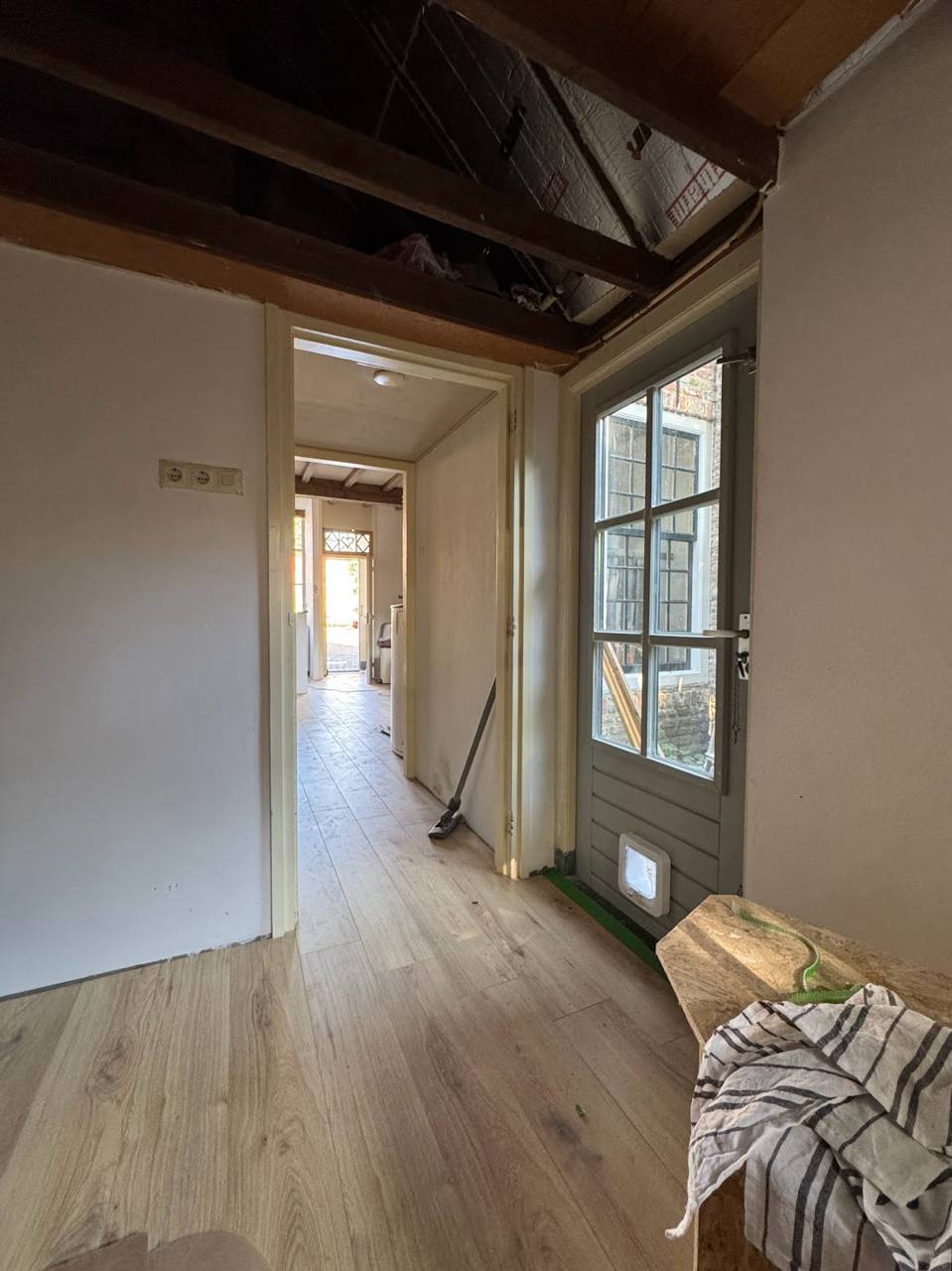 Renovated traditional hallway with new light wood flooring and exposed beams