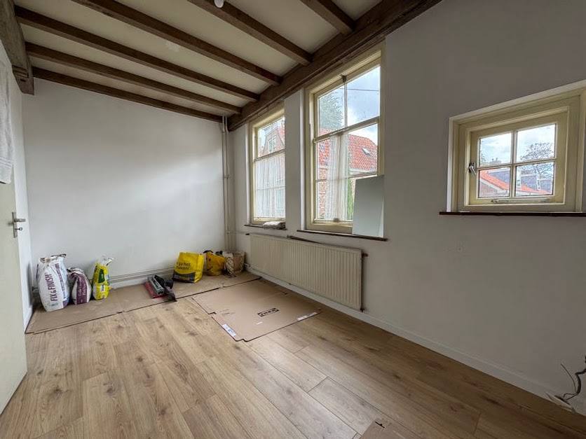 Bright bedroom with newly installed light oak flooring and white walls
