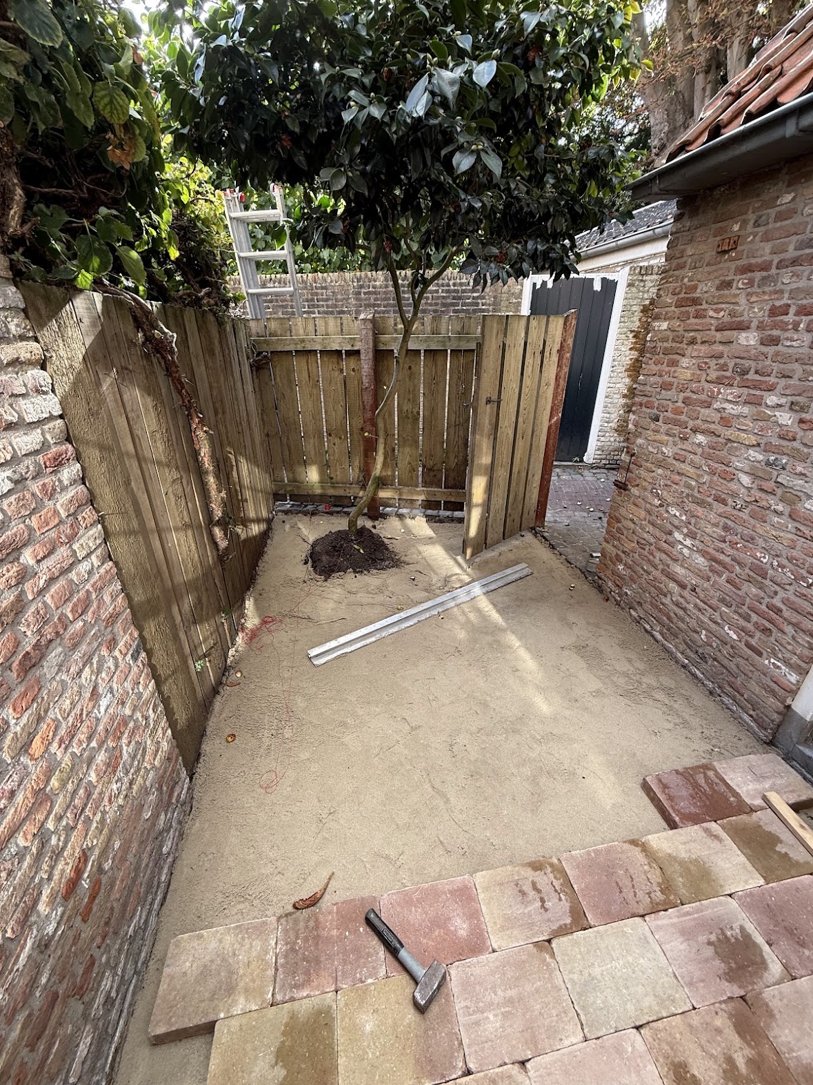 Courtyard garden area with newly laid mixed stone pavers and wooden fencing