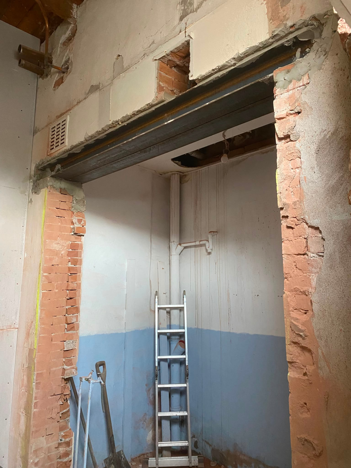 Full interior renovation with new steel support beam and stripped masonry walls by NIVA BUILDING