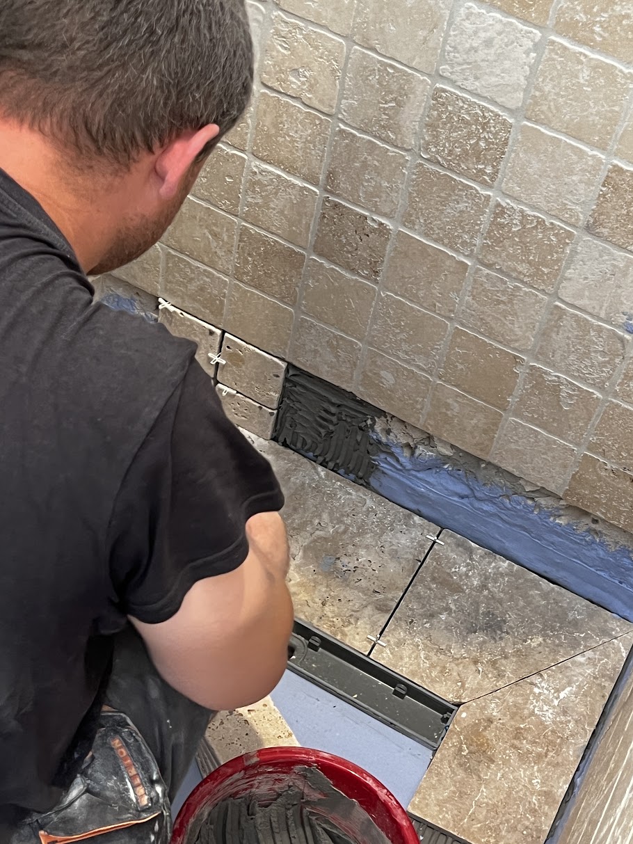 Close-up of beige wall and floor tiling in a shower with waterproof membrane