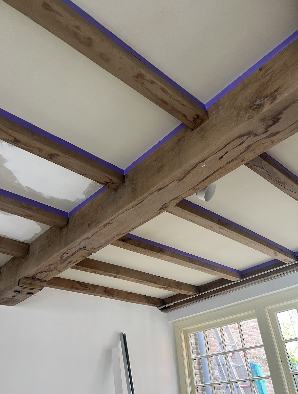 Rustic exposed wooden ceiling beams installed in a renovated interior