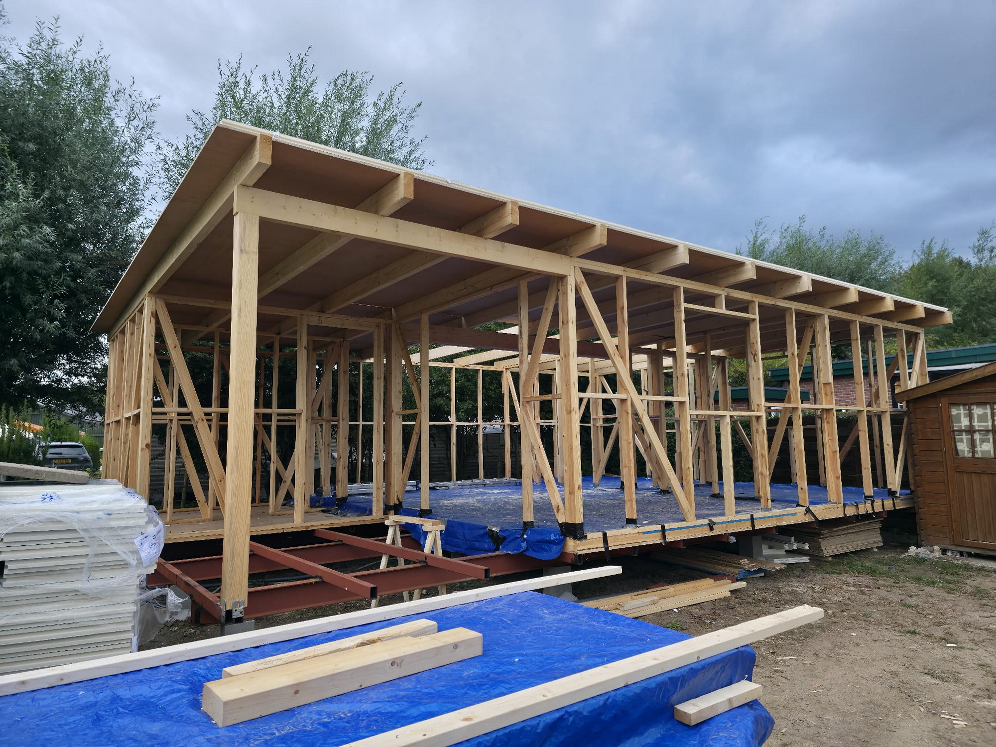 Wide view of the timber shell and roof structure under construction