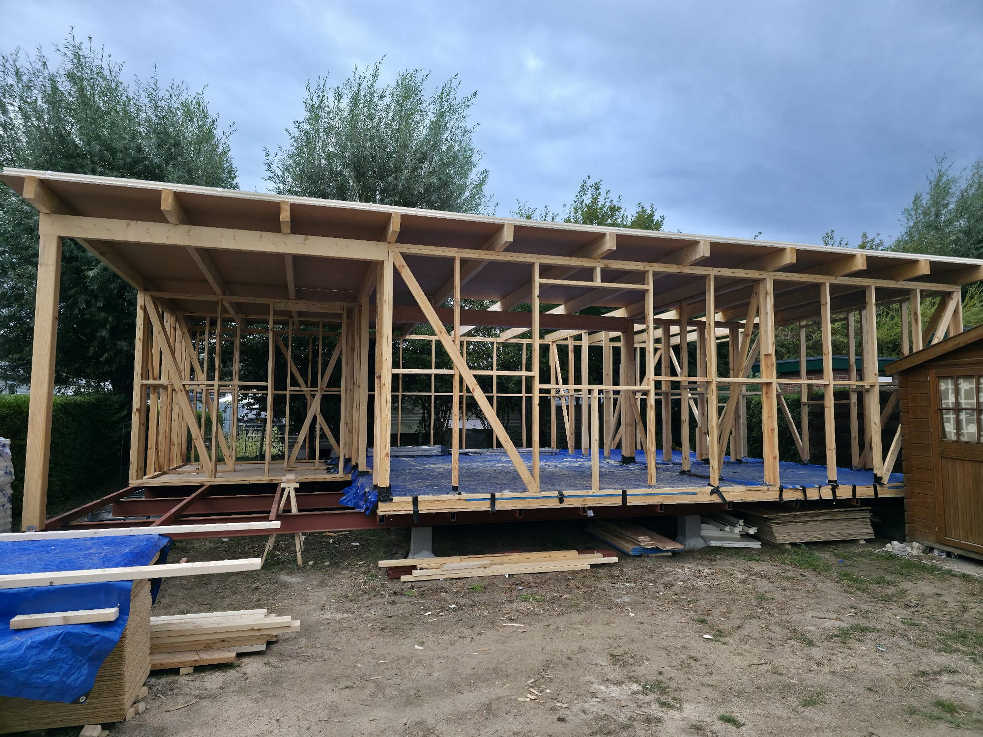 Front view of the timber frame with the first roof panels installed