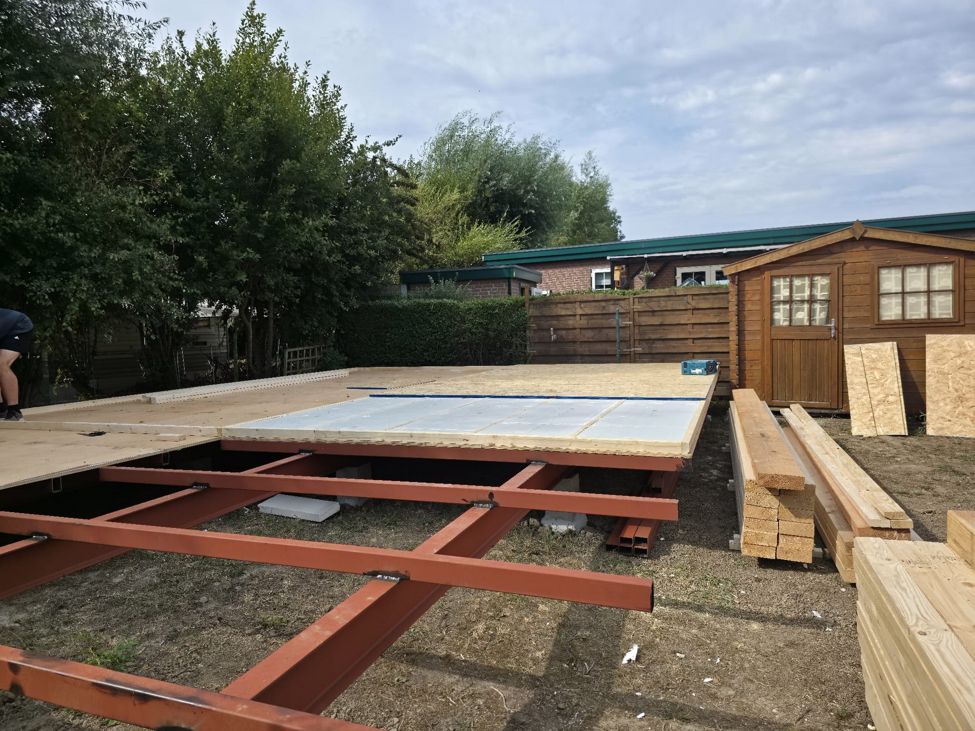 Floor construction in progress with insulation panels and OSB boards on a steel frame
