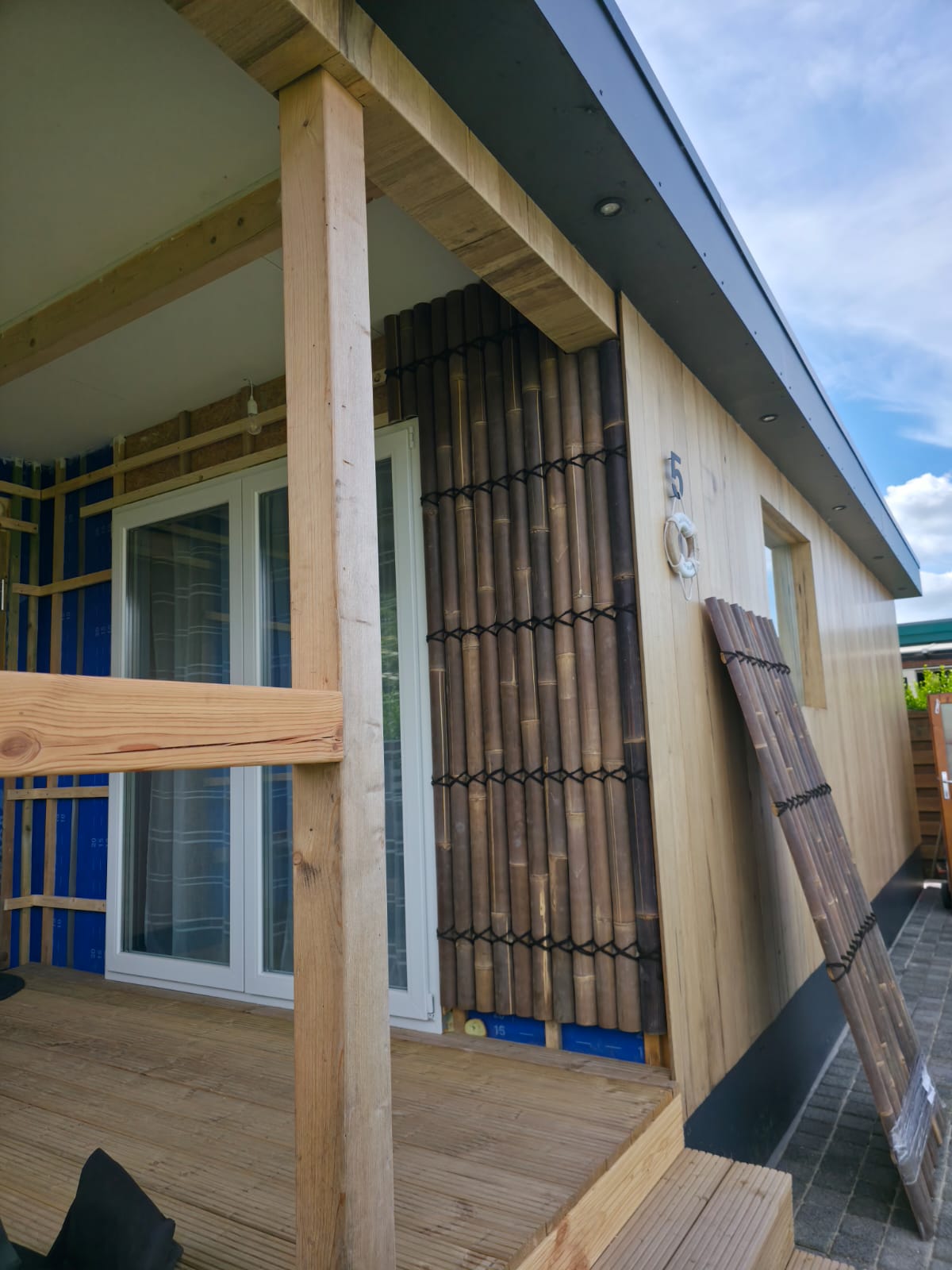 Timber cladding and bamboo feature panels fitted around the entrance