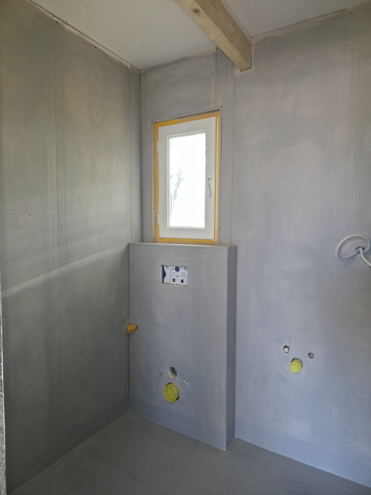 Bathroom drywall with concealed toilet frame, window niche and pipe rough-ins
