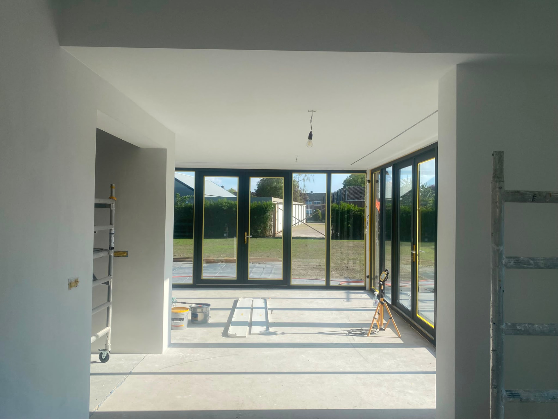Plastered house extension with large aluminium window frames
