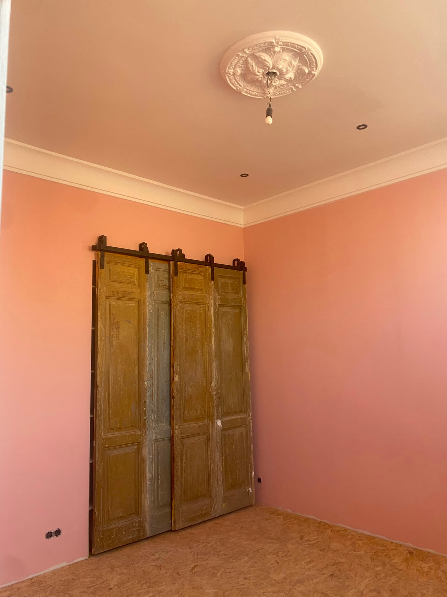 Freshly painted pink sliding barn doors in a finished interior