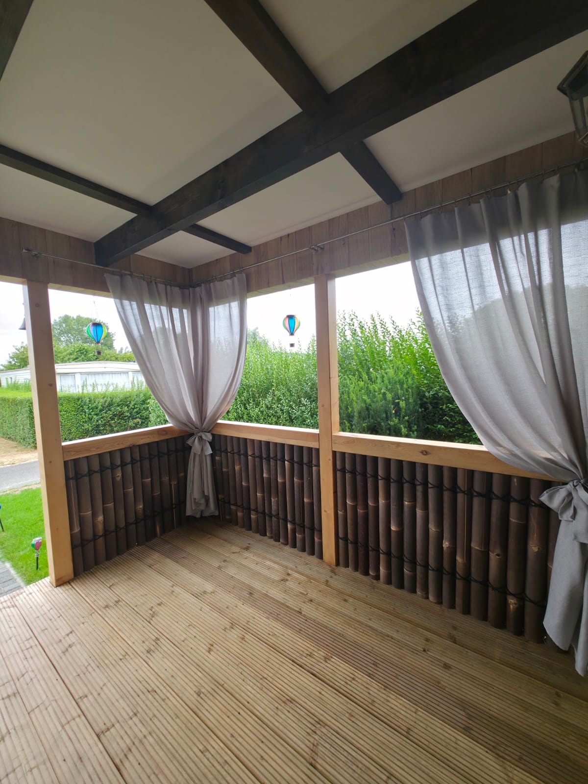 Finished covered timber terrace with bamboo panels and curtains