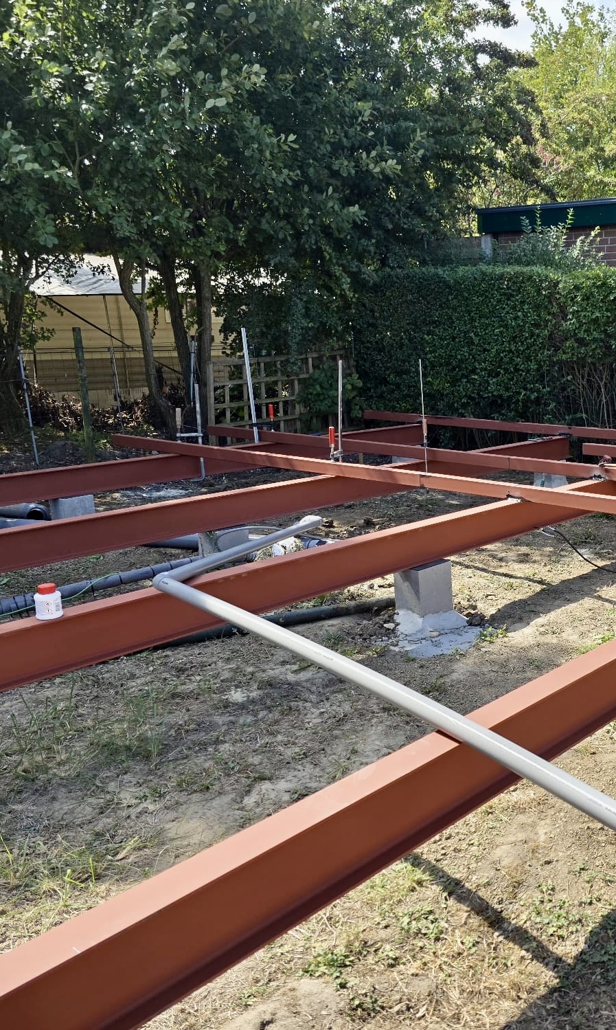 Steel base frame and utility pipe detail on the concrete foundation piers