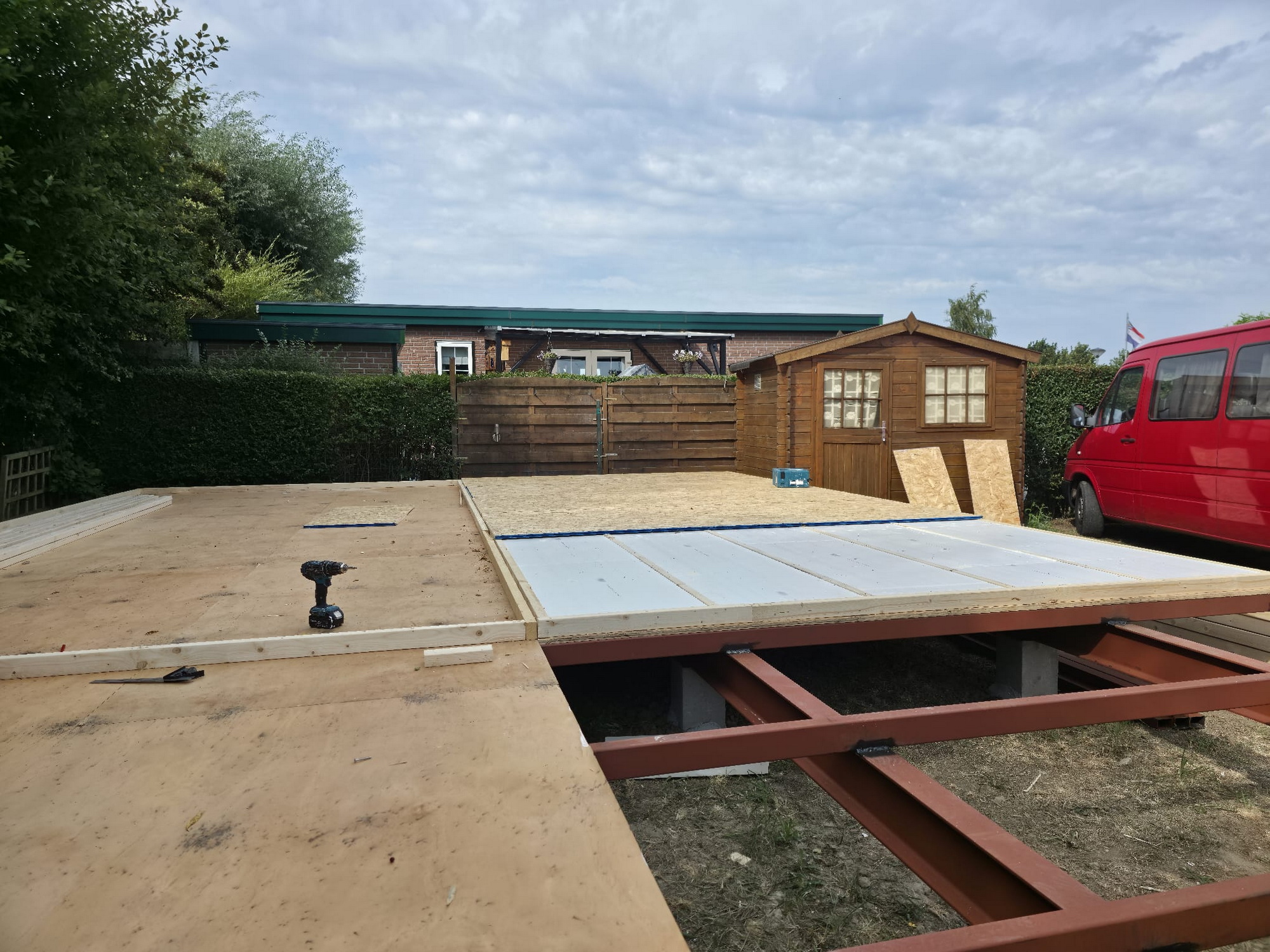 Floor boards and insulation panels being installed across the steel base